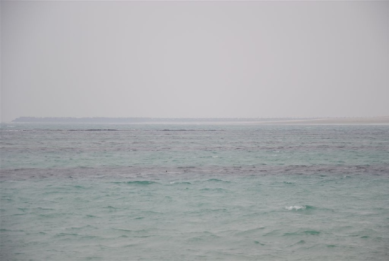 Die Nordostmole (i-punkt) von der Nordwestmole bei Nierigwasser von der Wasserkante aus über die Wasserfläche dazwischen gesehen 