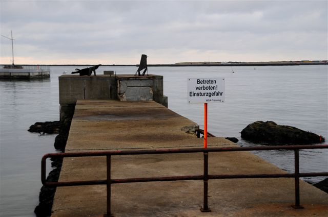 Aufnahme der Augustamole von der Ostkaje des Südhafens aus mit der Landungsbrücke im Hintergrund und dem Schild am Anfang der Augustamole mit dem Inhalt: Betreten Verboten Einsturzgefahr