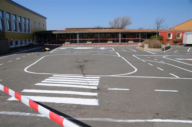 Weiße Linien auf dem dunkelgrau asphaltierten Schulhof stellen ein symbolisches Strassennetz dar.