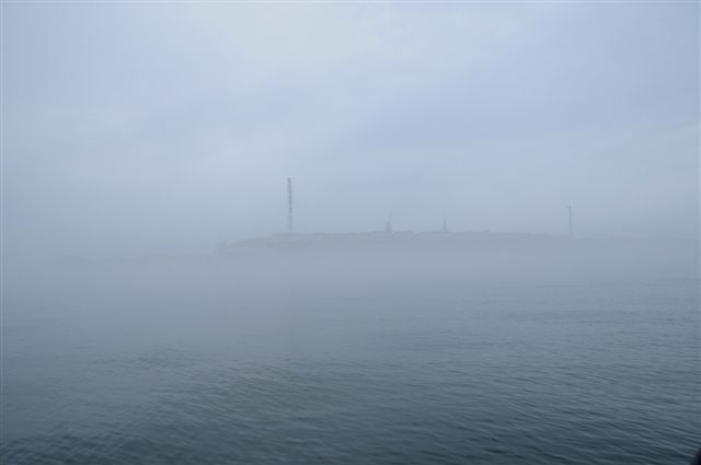Sehr dichter Nebel bei Helgoland . Nur das Oberland zeichnet sich durch den Nebel ab.