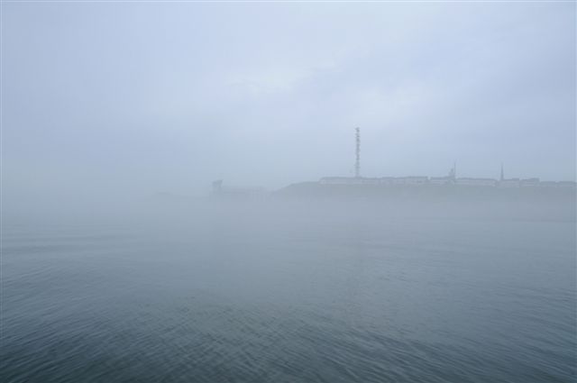 Sehr dichter Nebel bei Helgoland schafft eine gespentische Atmosphäre und das kaum erkennbare Hotel Atoll an der Landungsbrücke könnte genausogut ein plötzlich aus dem Nebel auftauchendes Schiff sein.