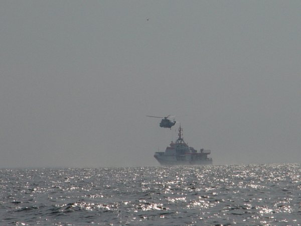 Der Seenotrettungskreuzer Hermann Marwede und ein Hubschrauber proben auf See die Übernahme von Personen.