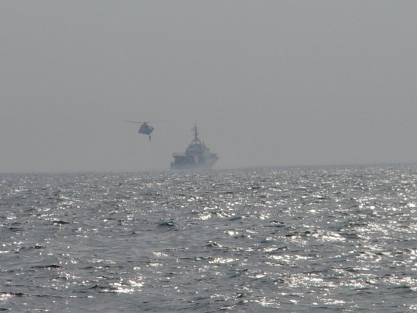 Der Seenotrettungskreuzer Hermann Marwede und ein Hubschrauber proben auf See die Übernahme von Personen.