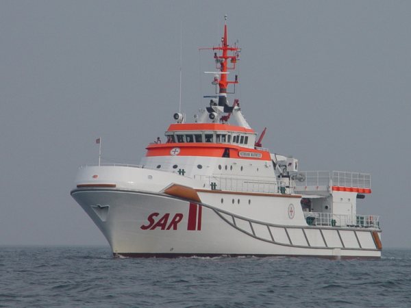 Der Seenotrettungskreuzer Hermann Marwede und ein Hubschrauber proben auf See die Übernahme von Personen.