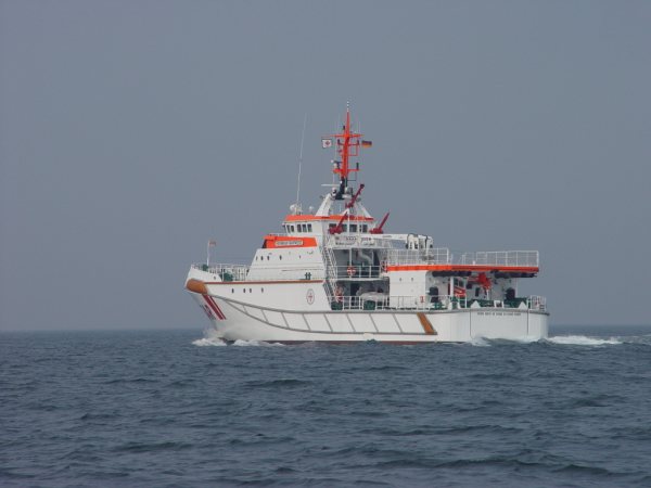 Der Seenotrettungskreuzer Hermann Marwede und ein Hubschrauber proben auf See die Übernahme von Personen.