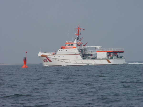 Der Seenotrettungskreuzer Hermann Marwede und ein Hubschrauber proben auf See die Übernahme von Personen.