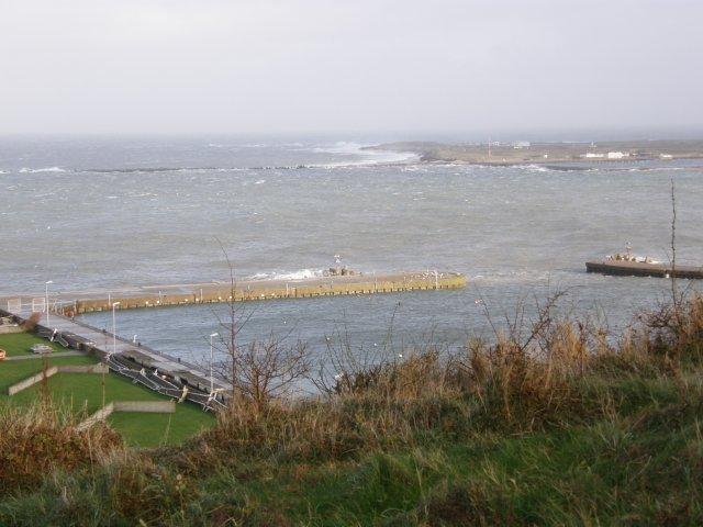 Blick von oberhalb des Helgoländer Wasserfalls über den Nordosthafen zum Nordstrand der Düne, wo die Brecher schon bis an den Haik gelangen.