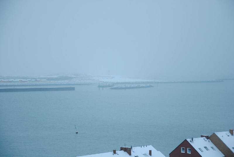 Tele-Aufnahme vom Helgoländer Falm zur schneebedeckten Düne hinüber.
