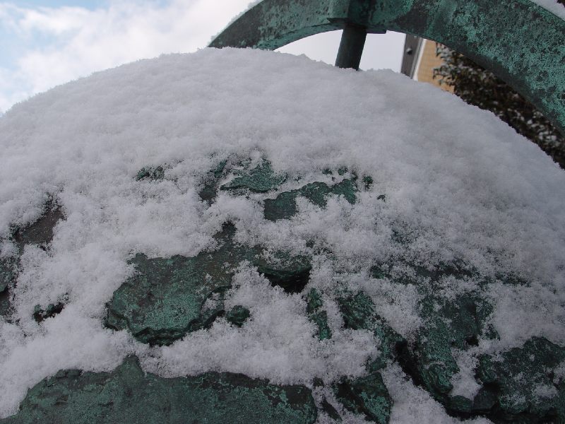 Mit einer sachten Handbewegung wurde der Schnee auf dem Schnee bedeckten Globus am Hintereingang des Helgoländer Aquariums entfernt, so dass im Bereich Europas Helgoland sichtbar wird.