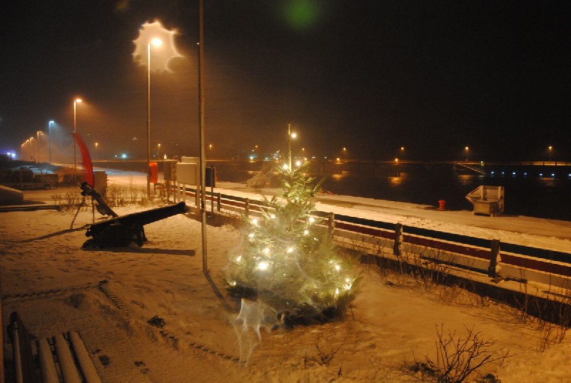 Der mit elektrischen Kerzen illuminierte Weihnachtsbaum vor dem Wetteramt Helgoland im Schneetreiben.