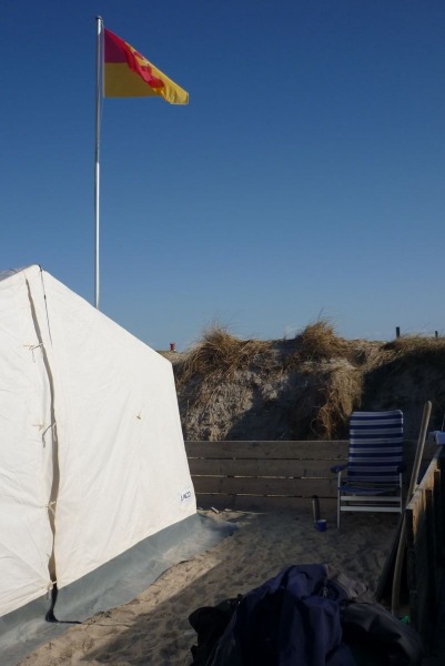 Camper Jesko baut sein Zelt auf dem Campingplatz Helgoland-Düne auf und wird dabei von zwei Stockenten ausgiebig und ziemlich unscheu begutachtet.