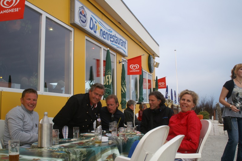 Der Chef des Helgoländer Dünenrestaurants mit Freunden am Tisch auf der Außenterrasse vor dem Dünenrestaurant.