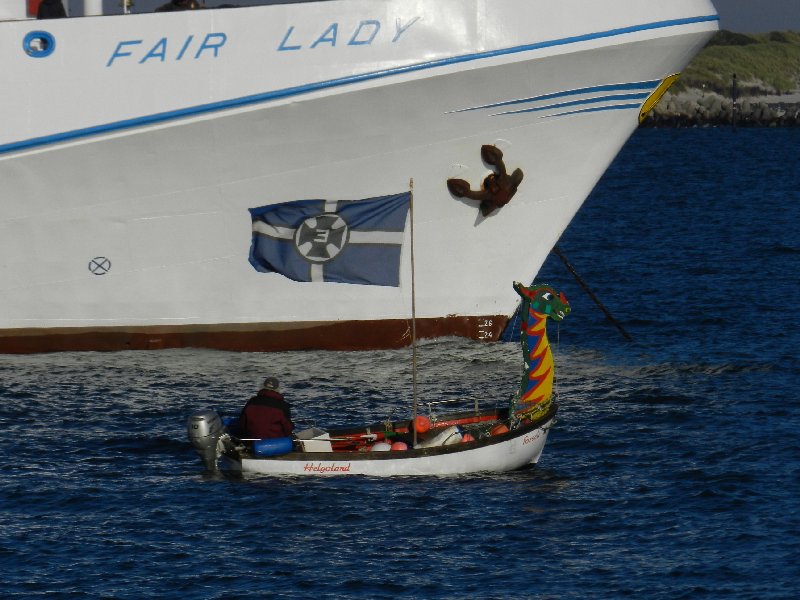 Das Passagierschiff Fair Lady auf der Helgoländer Reede wird zum letzten Mal in dieser Saison eingebootet, dazu liegt gerade das letzte Boot an der Helgoland-Pforte der Steuerbordseite.