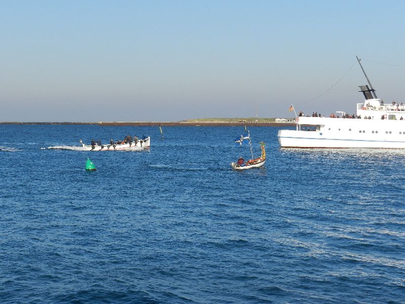 Das Passagierschiff Fair Lady auf der Helgoländer Reede wird zum letzten Mal in dieser Saison eingebootet, dazu liegt gerade das letzte Boot an der Helgoland-Pforte der Steuerbordseite.