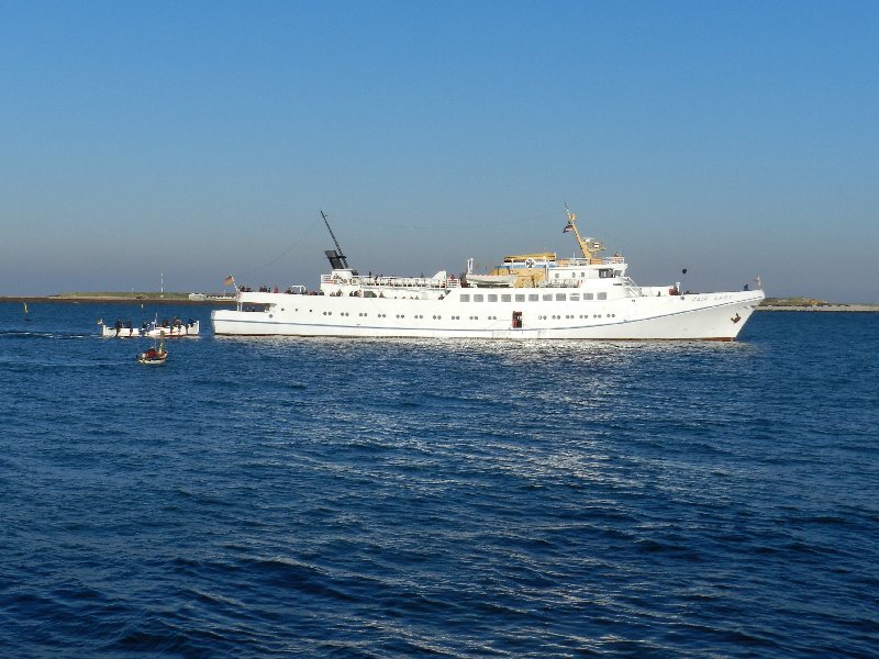 Das Passagierschiff Fair Lady auf der Helgoländer Reede wird zum letzten Mal in dieser Saison eingebootet, dazu liegt gerade das letzte Boot an der Helgoland-Pforte der Steuerbordseite.