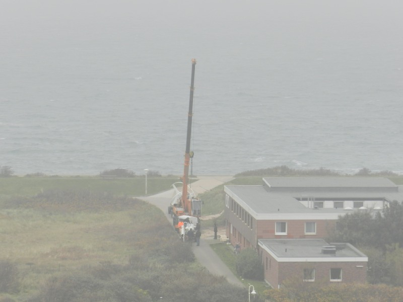 Ein  neues Windrad – ein Darrieus-Rotor – des Alfred-Wegener-Instituts auf Helgoland wird zum Einsatzort am Wilhelm-Mielck-Haus im Nordostgelände transportiert.