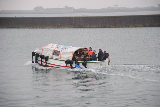 Helgoländer Börteboot, das im Wintereinsatz als Dünenfähre eine Art Zeltaufbau als Wetterschutz hat.
