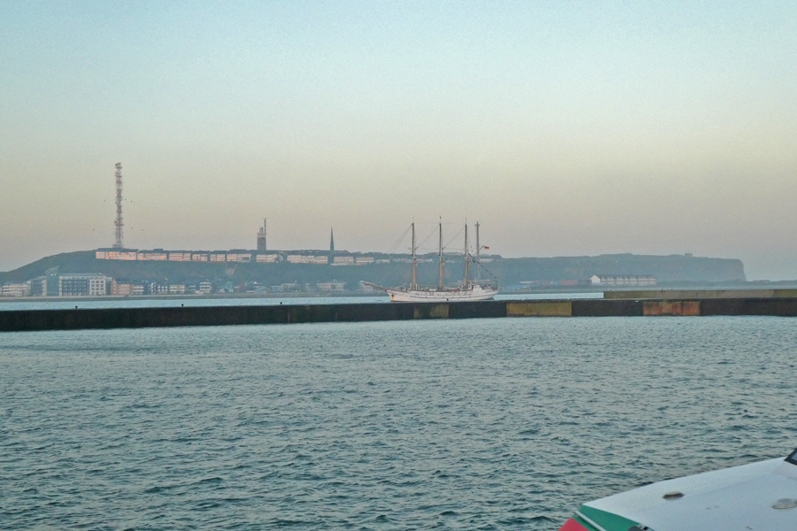 Ein Dreimaster-Segelschiff vor dem Kraftwerksschornstein, so dass es wirkt, als wäre sie ein Viermaster.