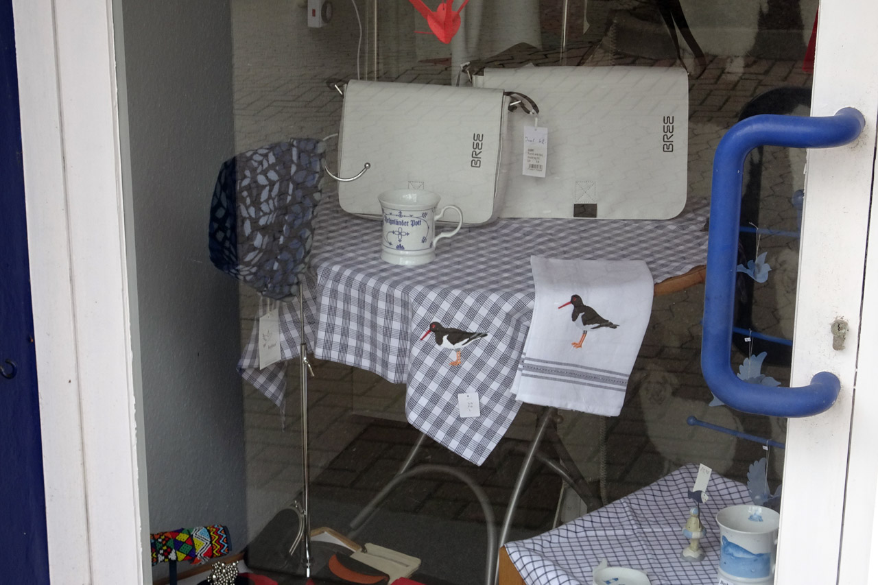 Geschirrtuch und Tischdecke mit Austernfischer-Motiv im Schaufenster vom Finnshop auf Helgoland.