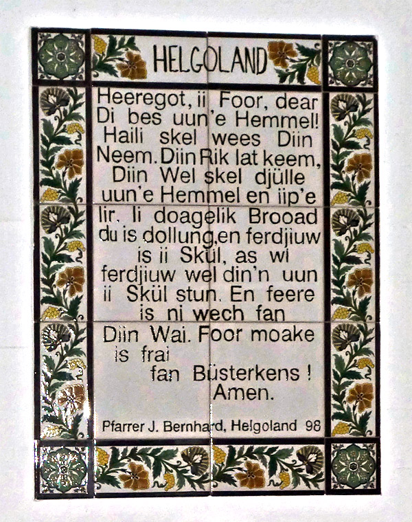 Eine von Pfarrer Bernhard gestiftete Majolikaplatte mit dem Vater unser auf helgoländisch auf Helgoland in der St. Michaels-Kirche.