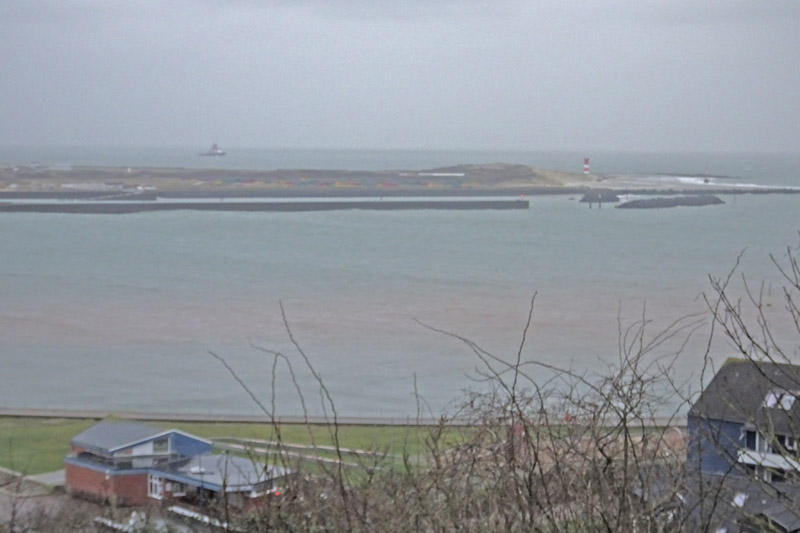 Durch starken Seegang zermahlener Buntsandstein färbt das Wasser zwischen Düne und Helgoland rot.