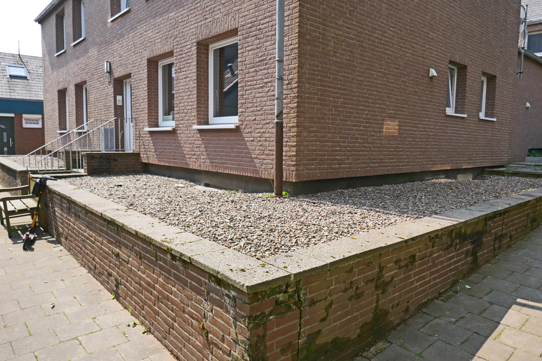 Die Gartenfläche vor einem Helgoländer Haus wurde komplett mit Kieselsteinen befüllt, keine Pflanze ist zu sehen.