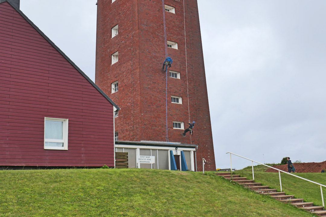 Industriekletterer am Leuchtturm auf Helgoland.