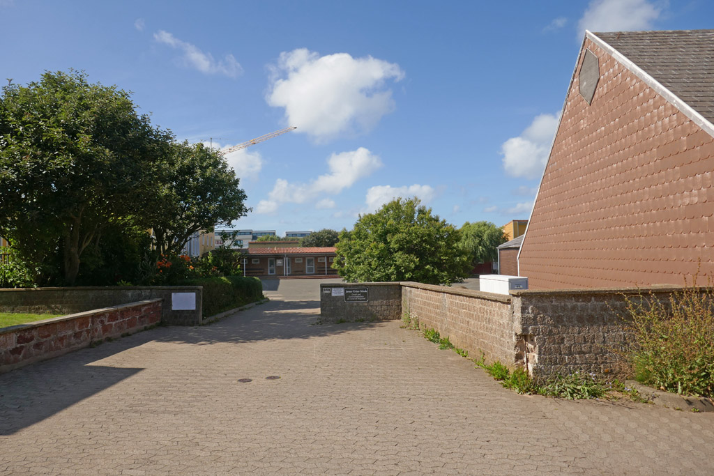 Haupteingang der James Krüss Schule auf Helgoland mit kaputter Mauer.