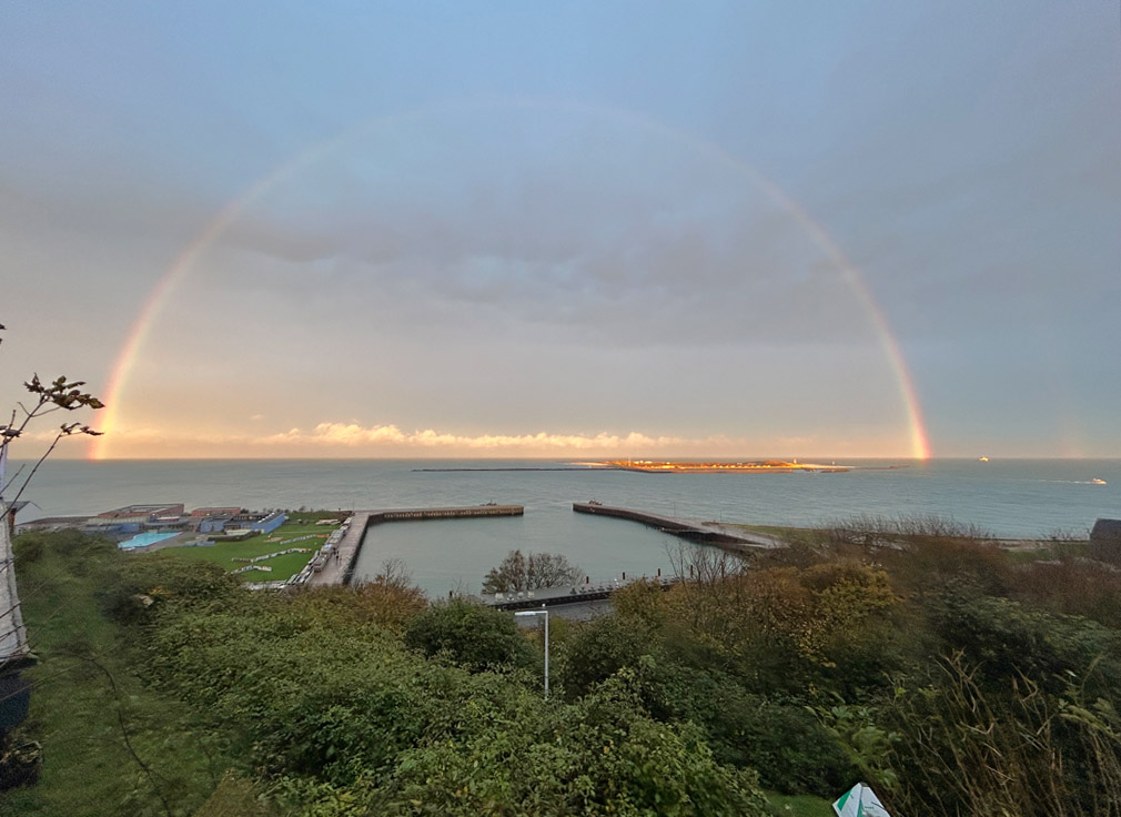 Regenbogen am Spätnachmittag über der Düne vom Falm auf Helgoland aus gesehen.
