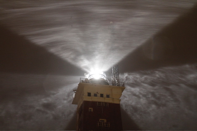 elgolands Leuchtturm bei Nacht und Schneetreiben.