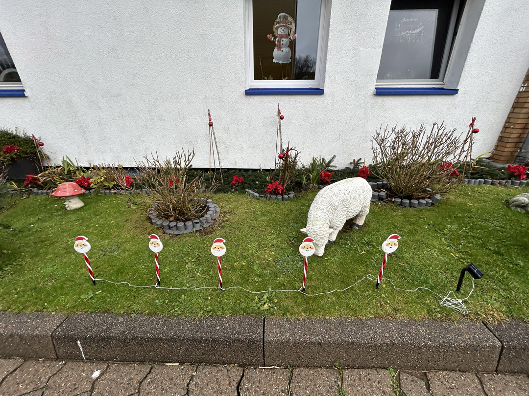 Ein Garten auf Helgoland mit Rasen, Blumen und Dekorationen .