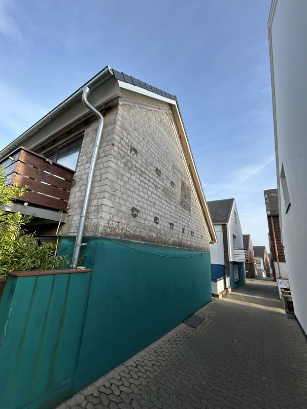 Bei einem Haus in der Berliner Stra&szlig;e auf Helgoland ist die Fassade zwecks W&auml;rmedammung abgebaut und dadurch das blanke Mauerwerk sichtbar.
