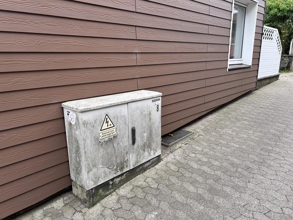 Ein stark verschmutzter Verteilerkasten verunziert die Ansicht eines Hauses auf Helgoland.