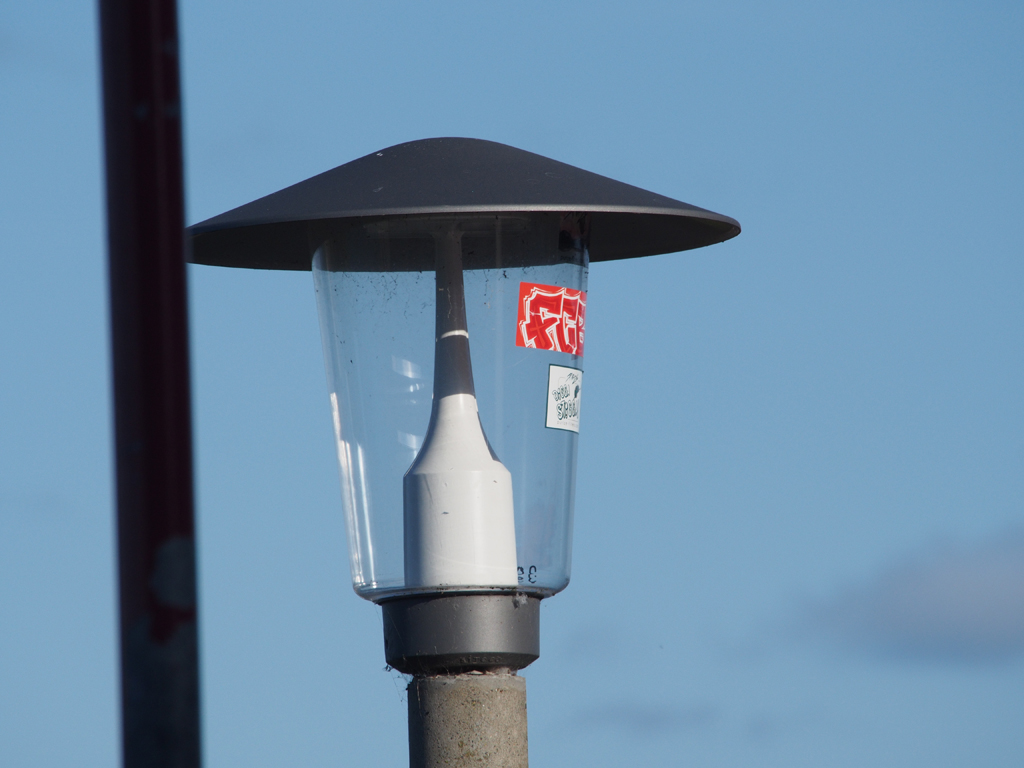 Erst war ein Aufkleber auf dem Lampenschirm einer Stra&szlig;enlaterne; 6 Tage sp&auml;ter ist ein weiterer dazugekommen.