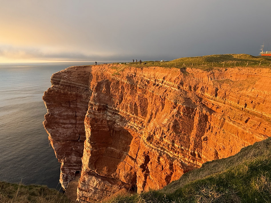 Der Steilfelsen an Helgolands Westseite wird von der tiefstehenden Wintersonne angestrahlt, so dass die Rott&ouml;ne des Buntsandsteinfelsen besonders hervorgehoben werden.