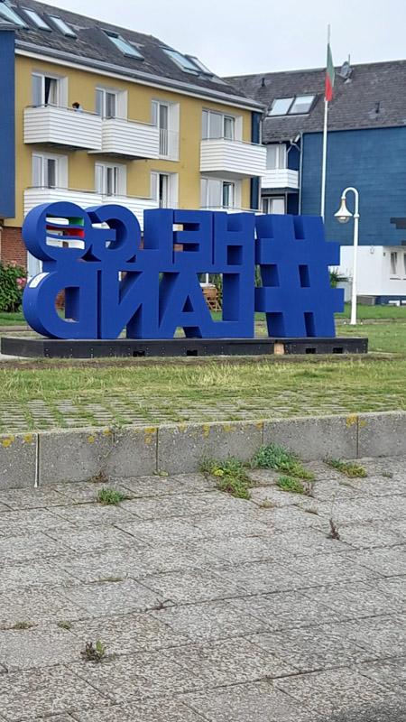 Ein Riesenschriftzug #Helgoland in blauen Buchstaben an der Kurpromenade.